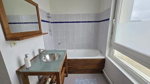 une salle de bain avec un lavabo et une baignoire dans l'établissement Le Voyageur Coucher de soleil vue mer, à Berck-sur-Mer