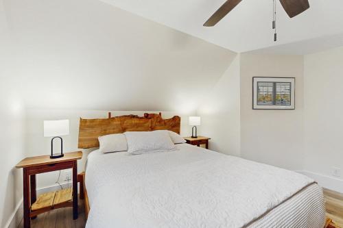 a white bedroom with a large bed and two lamps at Golden Hour Hideaway in Hancock