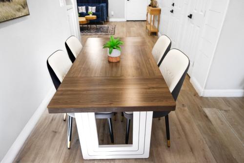 a wooden table with white chairs and a potted plant at Exotic Home Escondido 3 Bedroom by sdstay in Escondido