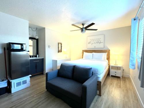 a bedroom with a bed and a chair and a television at San Dune Inn in Manzanita