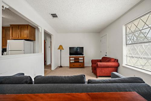 a living room with a couch and a red chair at Heidelberg Lodges in New Braunfels