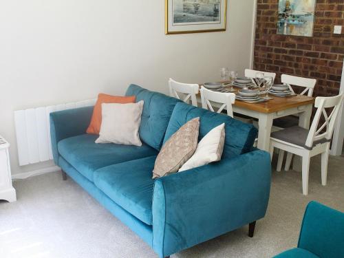 a blue couch in a living room with a table at Villa 9 in Cromer
