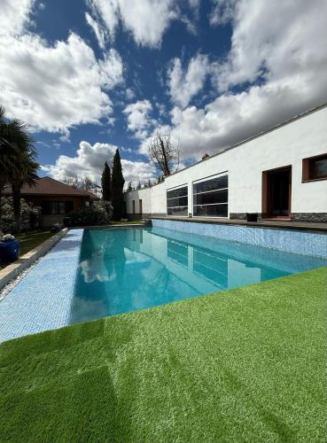 a swimming pool in front of a white building at Finca La Vega Bul in Estremera