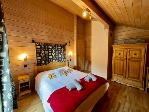ein Schlafzimmer mit einem Bett mit zwei Stofftieren darauf in der Unterkunft Le Murmure du Ruisseau, 4 étoiles avec sauna et terrasse in La Bresse