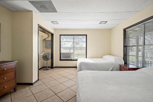 a bedroom with two beds and a window at Heidelberg Lodges in New Braunfels