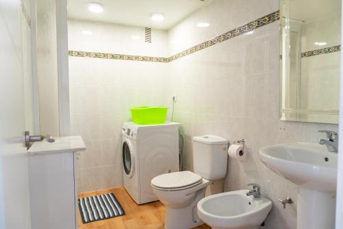 a bathroom with a white toilet and a sink at Nogalera apartamento 3 dormitorio con piscina in Torremolinos
