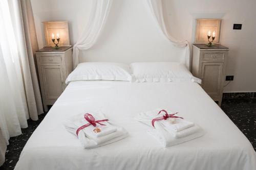 a white bed with two folded towels on it at Villa Giannina B&B in Taormina