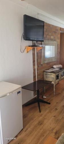 Una sala de estar con un televisor de pantalla plana en una pared. en Mrakes Guesthouse, en Odendaalsrus