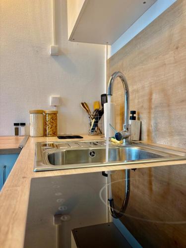 d'une cuisine avec un évier en acier inoxydable au comptoir. dans l'établissement LaTierraCota Centre ville Wifi Netflix, à Périgueux