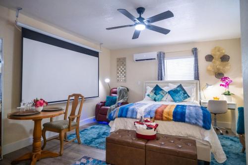 a bedroom with a bed and a table and a ceiling fan at Hidden Gem Luxe 1 BEDROOM & Patio in Cutler Bay