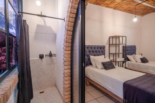 a room with a bed and a mirror at El Refugio de Sayulita - Solo Adultos in Sayulita
