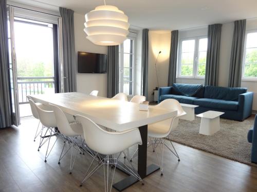 a living room with a table and chairs and a couch at Duinhof in Cadzand-Bad