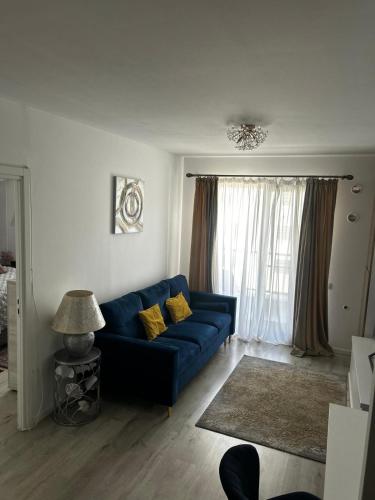 a living room with a blue couch and a window at H pipera in Voluntari