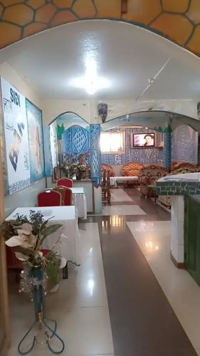 a lobby with a vase of flowers on a table at Chambre spacieuse à SIDI in Bafoussam
