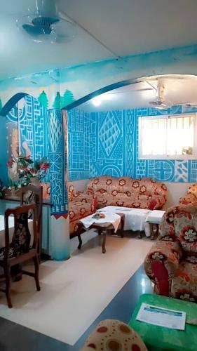a living room with a couch and blue walls at Chambre spacieuse à SIDI in Bafoussam
