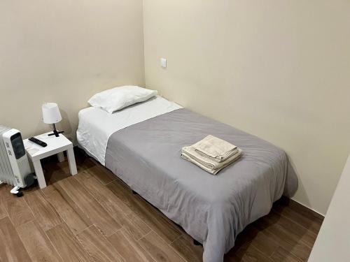 a bedroom with a bed and a table with a lamp at Acacias Rubras in Ferreira do Zêzere