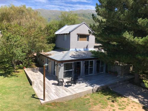 a house with a large deck in the yard at Los ciruelos - Casas de Motaña in Tafí del Valle