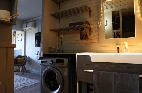 Un baño con lavadora y lavabo. en Aloha Studio - Cosy & Smart, en Papeete