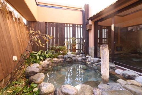 a small pool of water in front of a building at Dormy Inn Matsumoto in Matsumoto