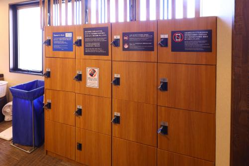 a row of lockers with signs on them at Dormy Inn Matsumoto in Matsumoto