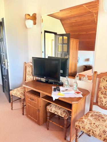 a room with a desk with a tv and a mirror at Pensjonat Rezydencja Zuzanna Bed&Breakfast Sucha Beskidzka in Sucha Beskidzka