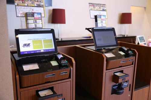 a cash register with a laptop on top of it at Dormy Inn Matsumoto in Matsumoto