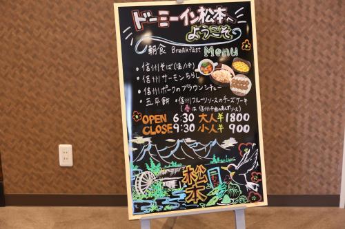 a chalk board with a menu on a wall at Dormy Inn Matsumoto in Matsumoto