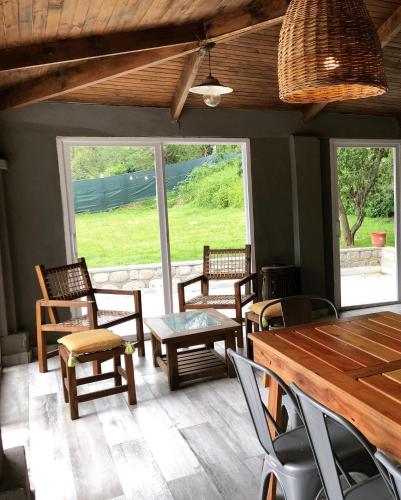 a room with chairs and tables and a large window at Los ciruelos - Casas de Motaña in Tafí del Valle