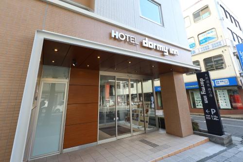 a hotel building with a sign on the front of it at Dormy Inn Matsumoto in Matsumoto