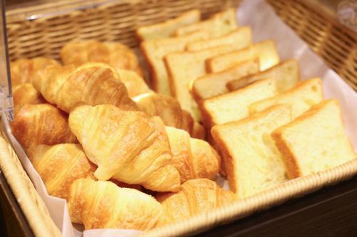 a display of bread and pastries in a display case at Dormy Inn Matsumoto in Matsumoto