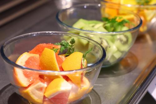 a glass bowl filled with fruit on a table at Dormy Inn Matsumoto in Matsumoto