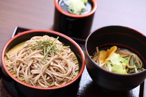 three bowls of noodles and vegetables on a table at Dormy Inn Matsumoto in Matsumoto