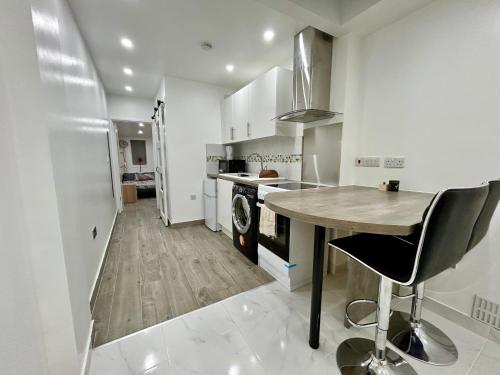 a kitchen with a table and chairs in a room at Verb Studio - North London Enfield Self Catering Holiday - work accommodation in Enfield