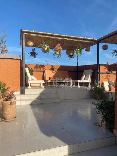a patio with chairs and a pergola at Riad Lyna in Marrakech