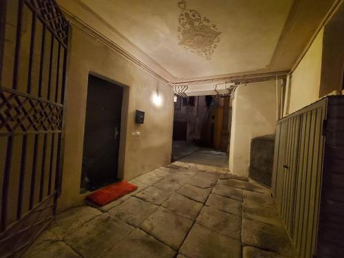 an empty hallway in an old building with a door at Dimora D'Arte in Ferrara