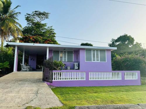 a pink house with a fence in front of it at Purple Sunset - Walk to Malecon & Beaches in Vieques