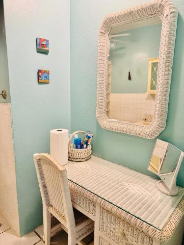 a bathroom with a wicker vanity with a mirror at Purple Sunset - Walk to Malecon & Beaches in Vieques