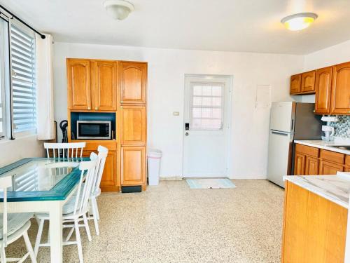 a kitchen with a glass table and a refrigerator at Purple Sunset - Walk to Malecon & Beaches in Vieques
