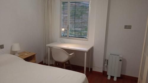a bedroom with a desk and a chair and a window at Mediterraneo-Chic 120 in Benicàssim
