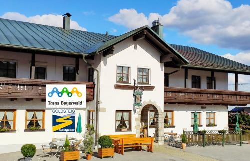 a building with a sign in front of it at Pension Philippsreut "Zum Pfenniggeiger" Am Goldsteigwanderweg in Philippsreut