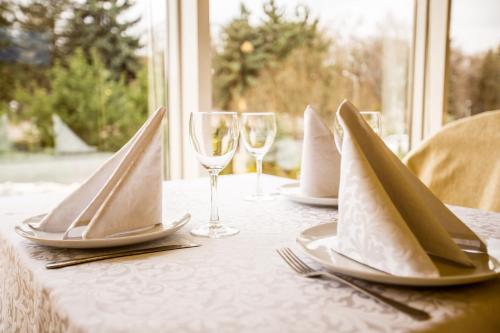 a table with glasses and plates and napkins on it at Bukovyna Hotel in Chernivtsi