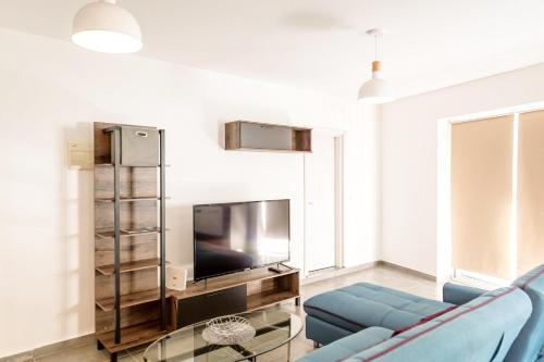 a living room with a blue couch and a tv at Luxury 3 Bedroom Apartment in Sliema - Walk to Beach & Dining in Sliema