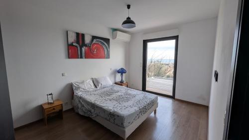 une chambre avec un lit et une grande fenêtre dans l'établissement Villa with sea and mountain views, à Furiani