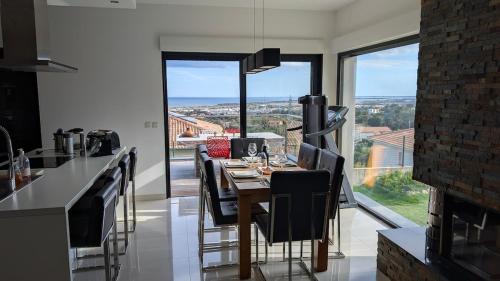 une salle à manger avec une table et une grande fenêtre dans l'établissement Villa with sea and mountain views, à Furiani