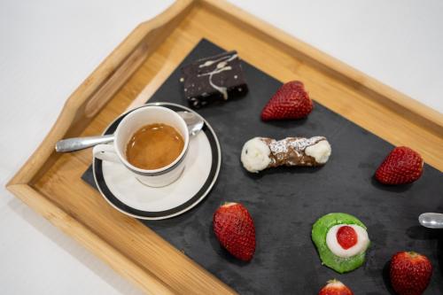 un vassoio con una tazza di caffè e fragole di Le Dimore - Ponte 7 a Palermo