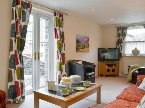 a living room with a coffee table and a tv at Rolton House in Ambleside