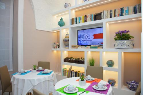a dining room with two tables and a tv at Hotel Villa Di Sorrento in Sorrento