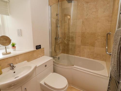 a bathroom with a sink and a toilet and a shower at Christon Well Cottage in Alnwick