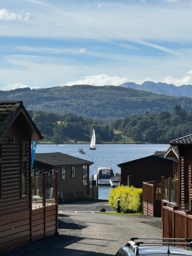 a sailboat in the water with houses and a boat at V+B Hygge in Windermere