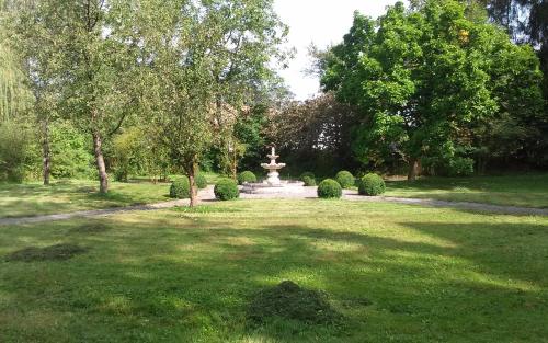 a park with a fountain in the middle of a field at B&B Villa Belle Epoque in Durbuy